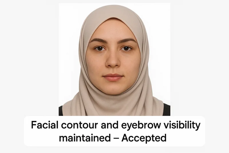 Passport photo of a person wearing a hijab with full facial contour and eyebrows visible